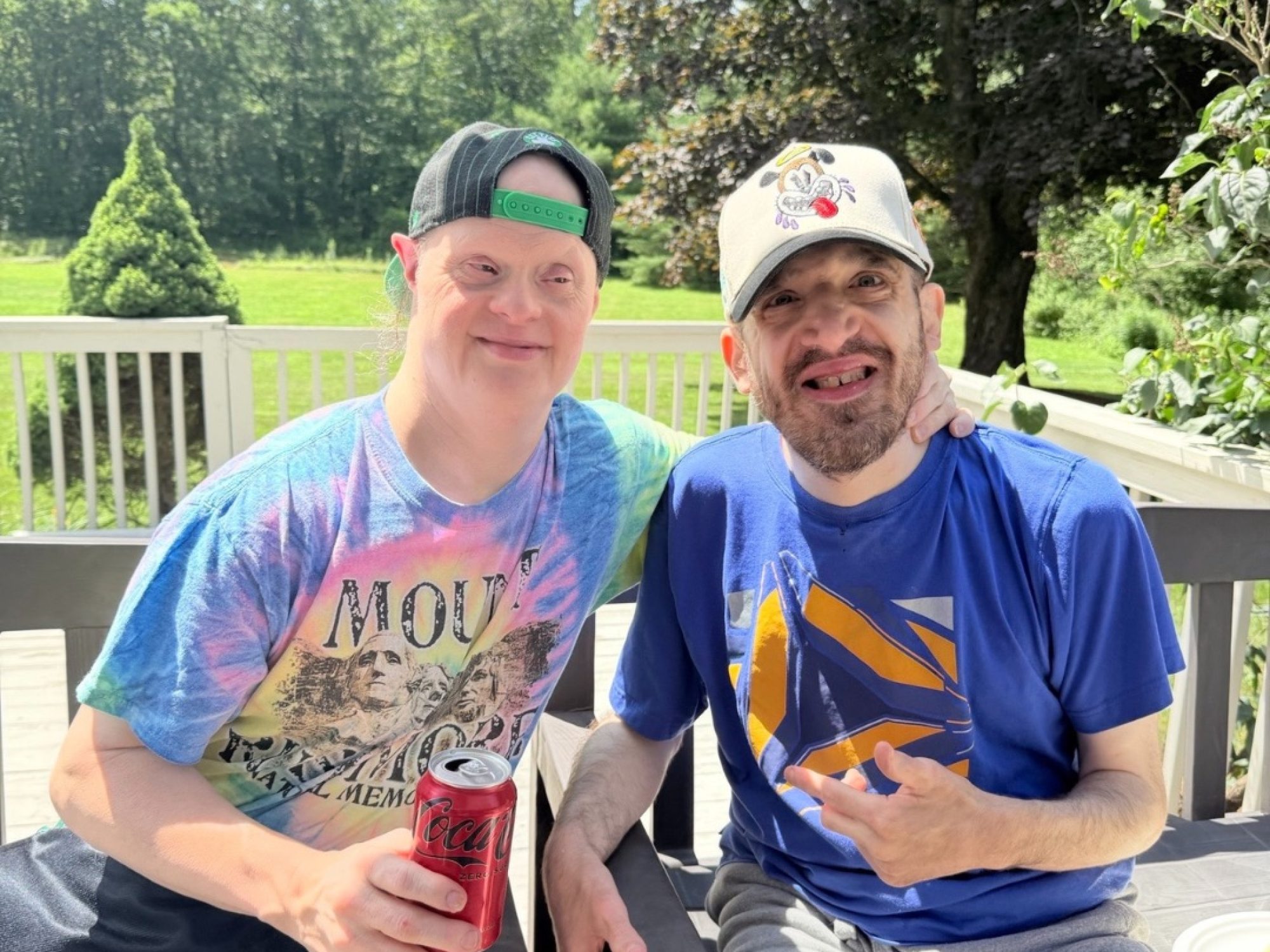 Two program participants smiling together outdoors on a deck